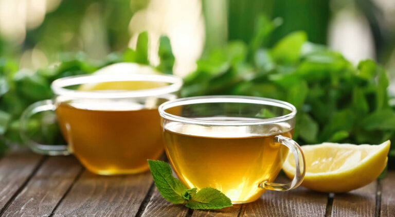 green tea in tea cups and green leaves