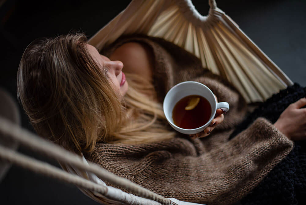 Can you mix green and black tea? Woman sitting in a hammock drinking tea