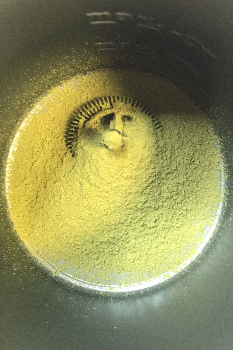Matcha powder sifted into a milk frother for matcha
