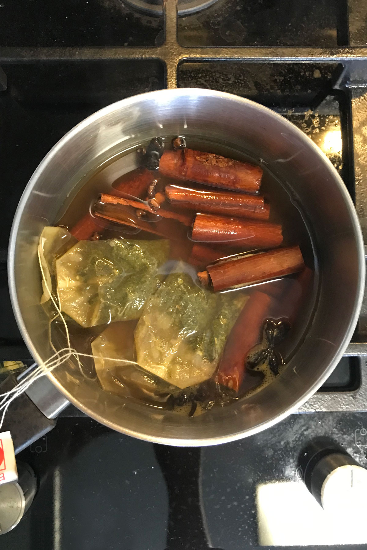 Simmer tea bag and spices in a pot of water to make Thai green tea