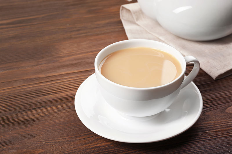Regular cup of milk tea in a tea cup and saucer