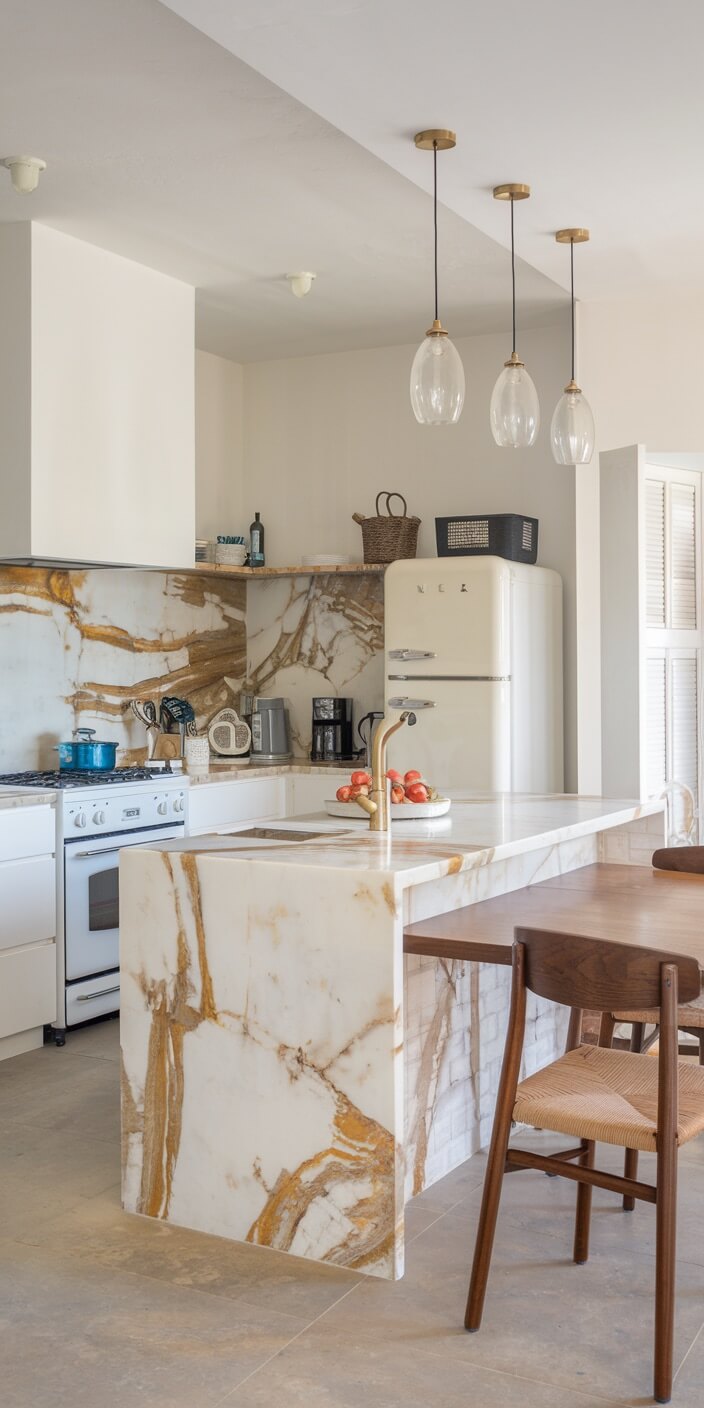 Modern kitchen with marble countertops, wooden furniture, retro refrigerator, and pendant lights. Open shelving holds kitchen essentials and decor.