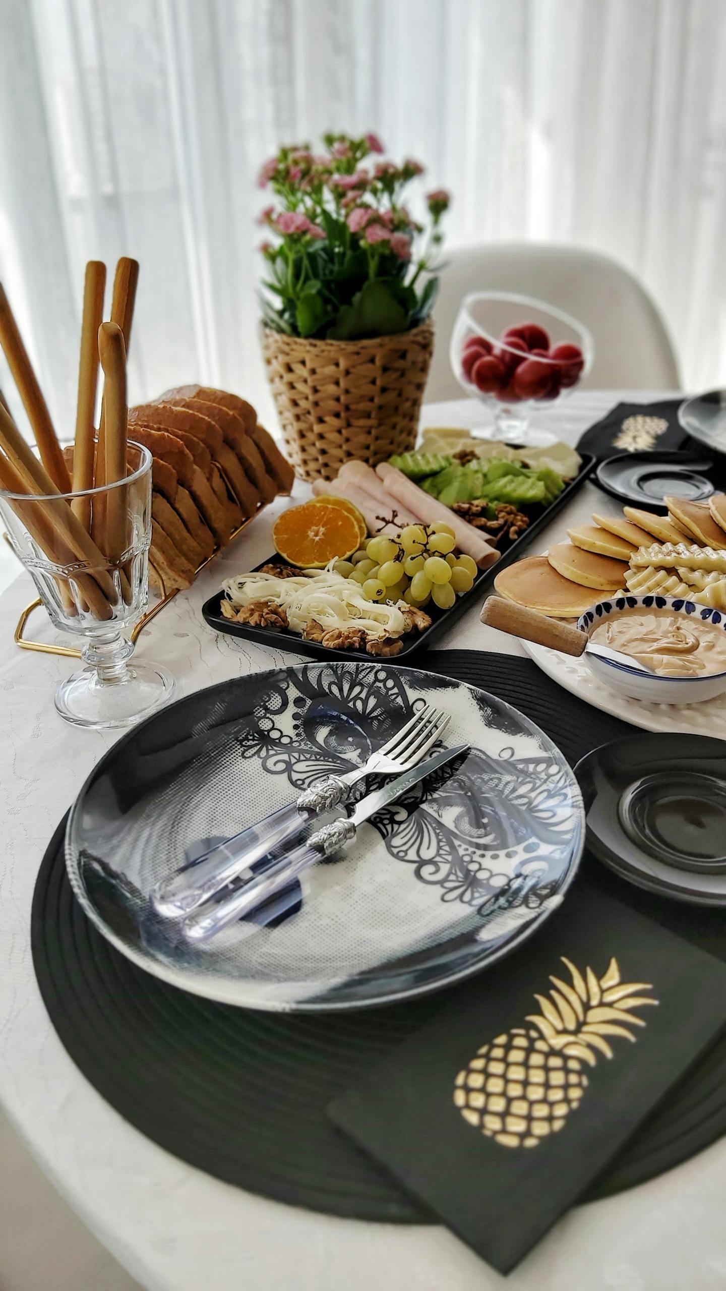 Chic breakfast table with diverse food items, fresh fruits, and floral decor for a perfect morning meal.