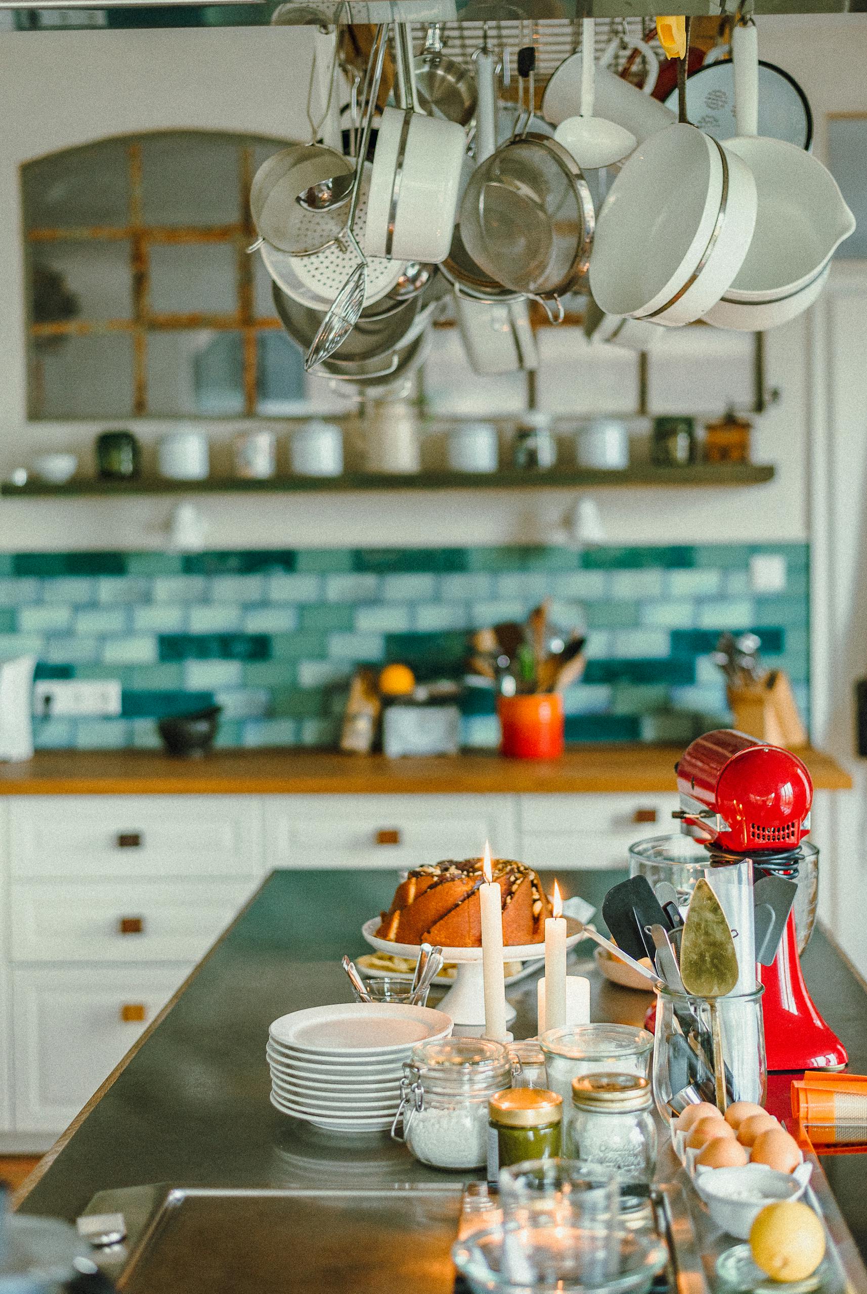 Cozy kitchen space in Düsseldorf featuring hanging utensils and a modern kitchen island setup.