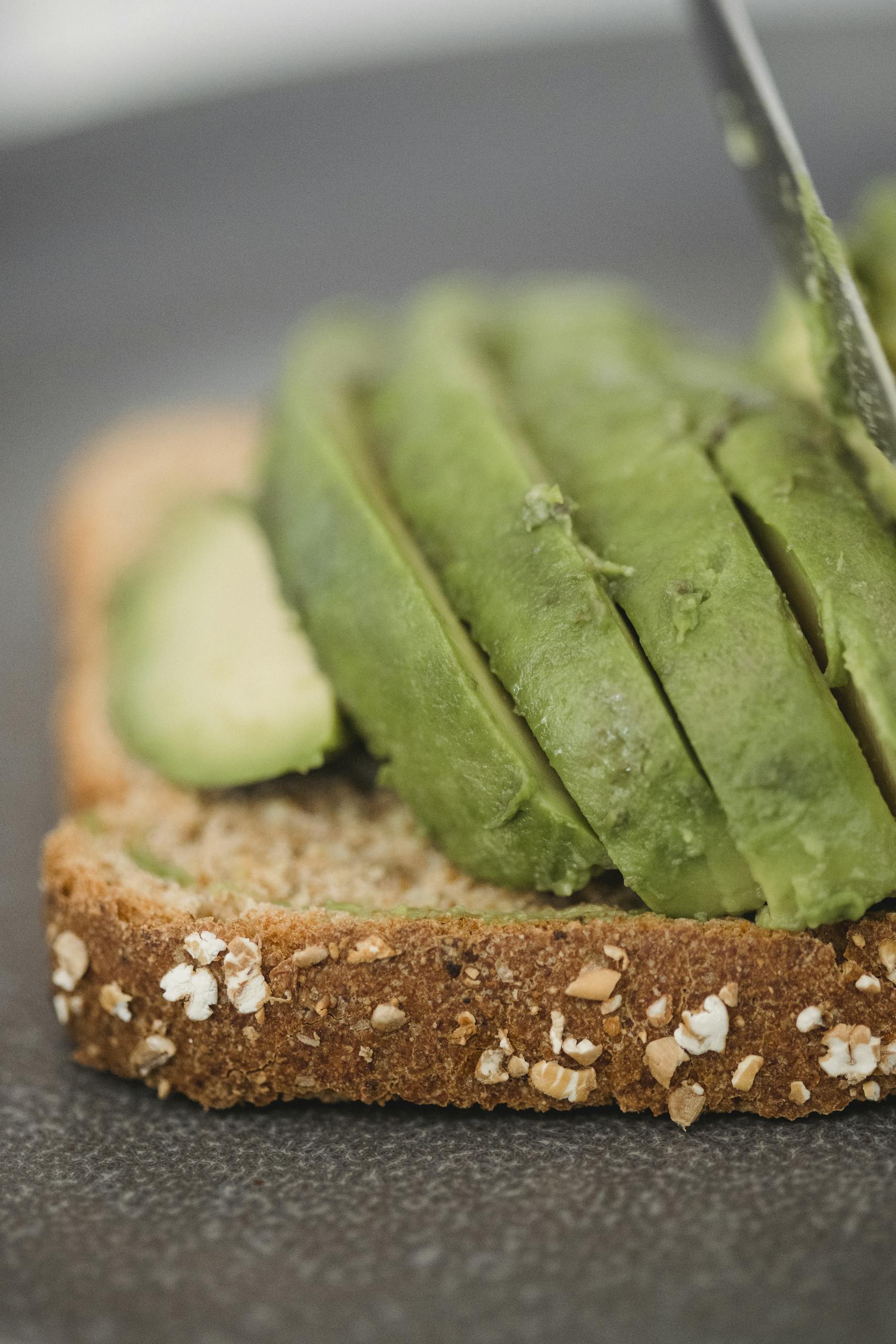 Delicious close-up of sliced avocado topping multigrain toast, perfect for a healthy breakfast.