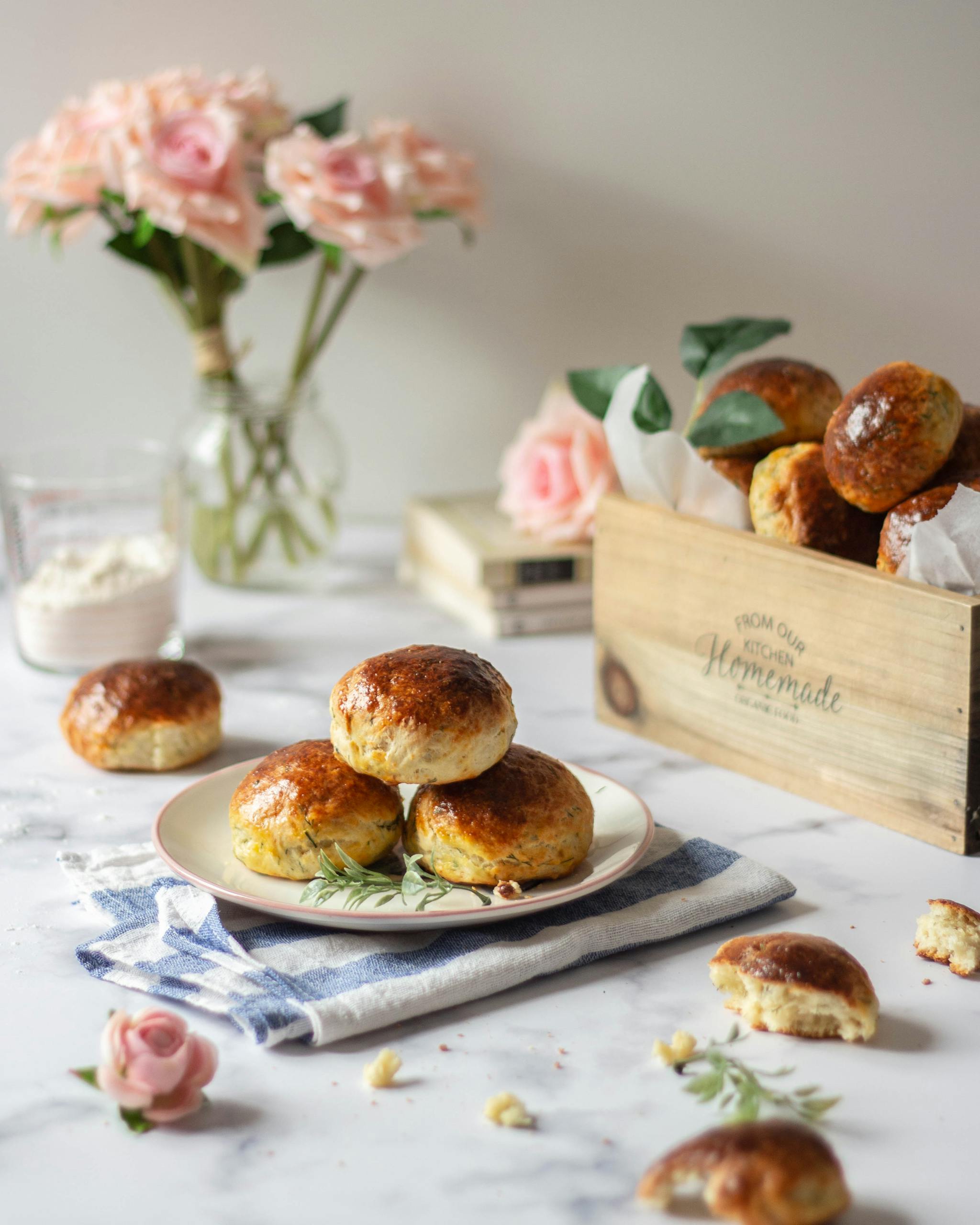 Delicious homemade scones on a plate with pink roses and rustic box.