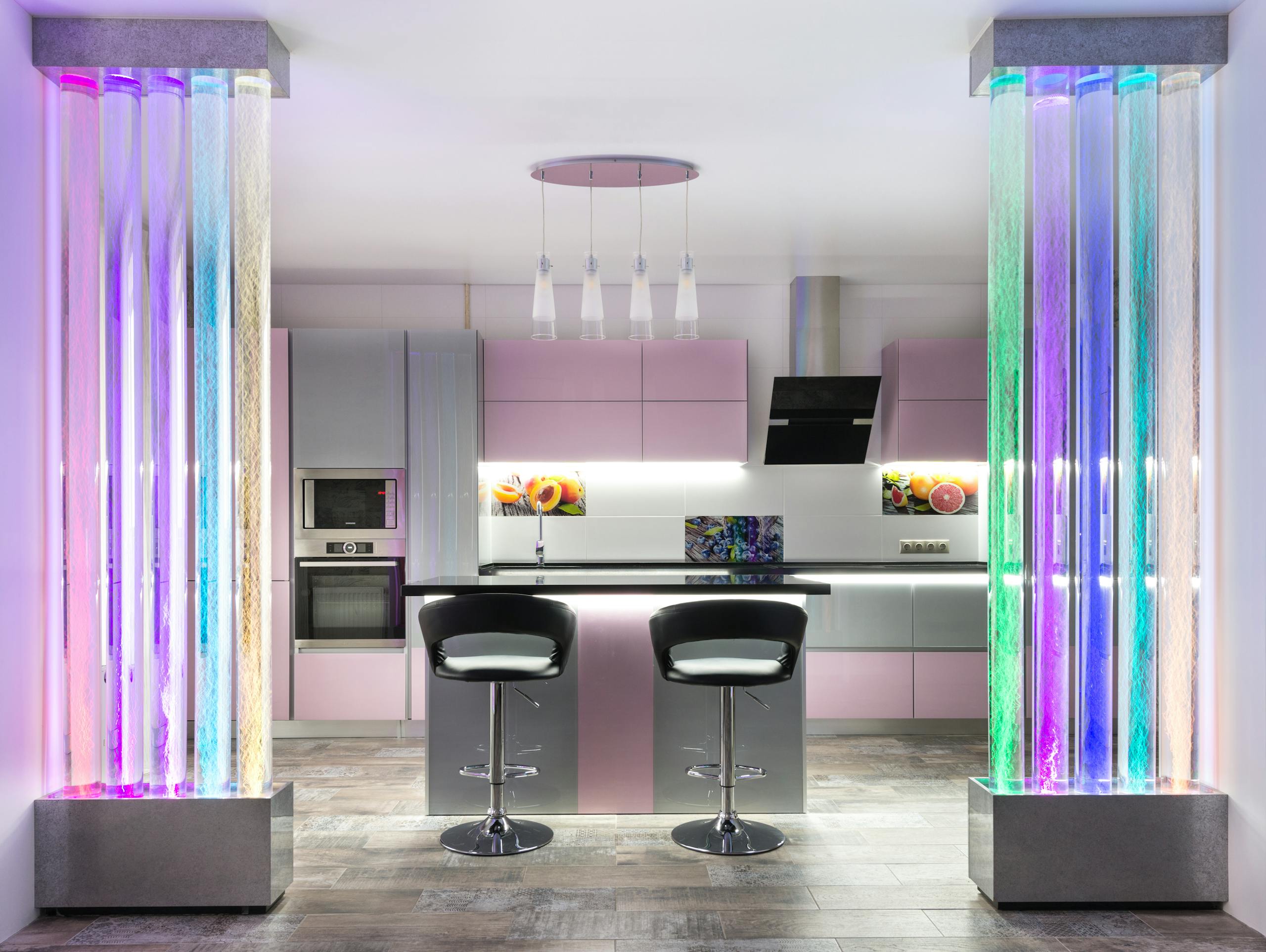 Explore this spacious modern kitchen with creative lighting and colorful design elements.