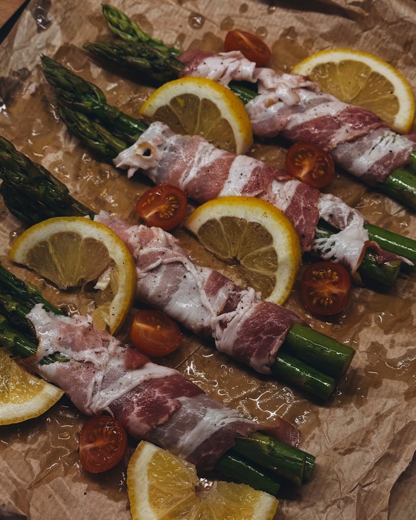 Gourmet appetizer with prosciutto, asparagus, and citrus slices.